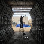 Production Designer Fred Busch paints the inside of a futuristic storage facility.